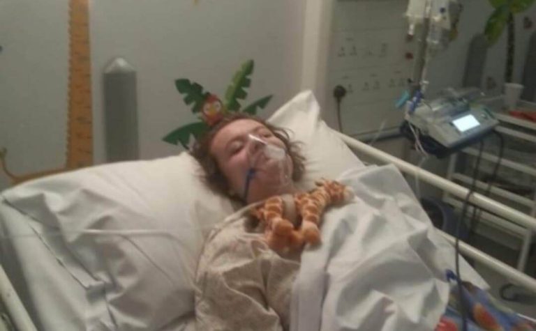 Leah after spinal surgery with giraffe toy