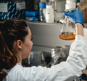 Female researcher looking at flask