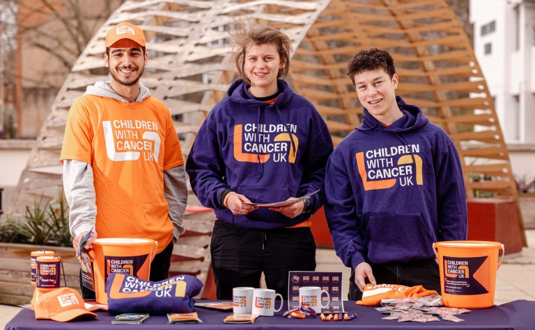 three fundraising supporters with a table of fundraising material