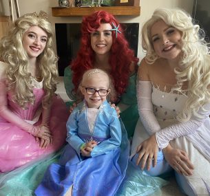 Dulcie dressed as a princess, surrounded by other princesses.
