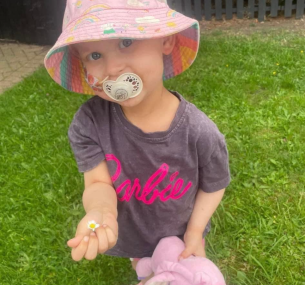 Gracie with dummy and nose tube in garden