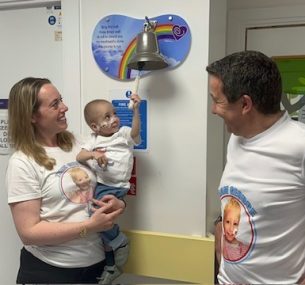 George ringing the bell with family