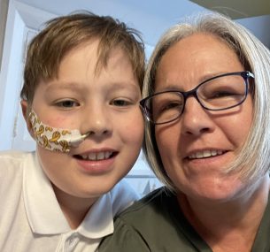 Harrison and his mum smiling at the camera.