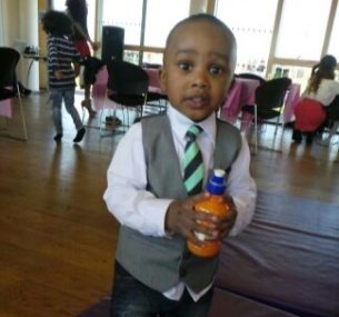 Chizi wearing a tie holding an orange bottle.